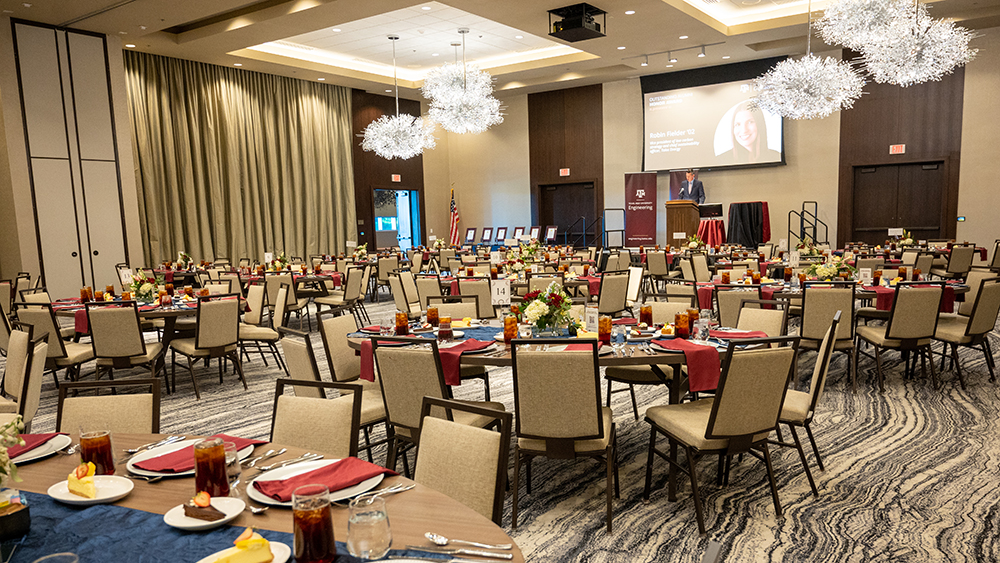 The ballroom is set up with round banquet tables. 