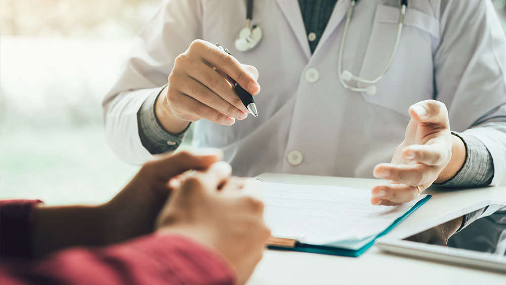 health care provider at desk with patient