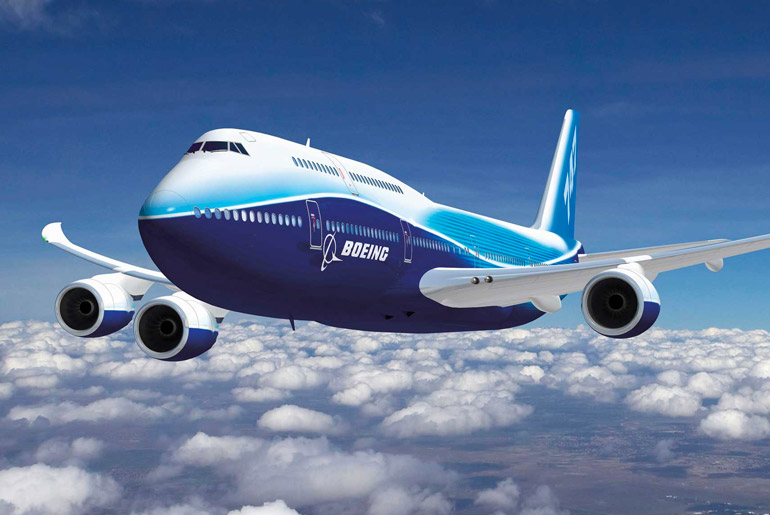 Large Boeing airplane in flight above clouds