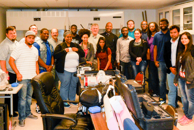 Prairie View A&M University students standing around laboratory equipment