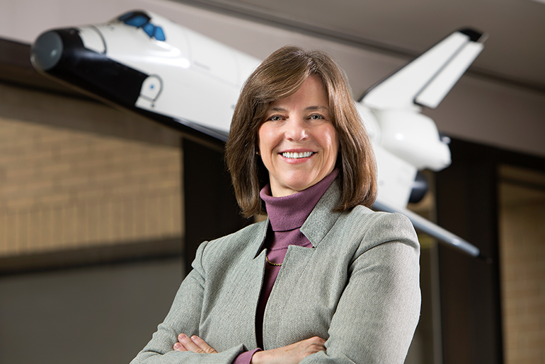 Dr. Bonnie J. Dunbar in front of NASA space shuttle replica