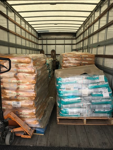 Image of bags of dog food piled inside of a warehouse container