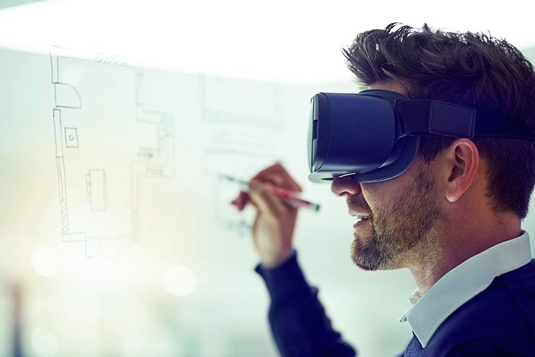 Man wearing virtual reality goggles writing on a whiteboard