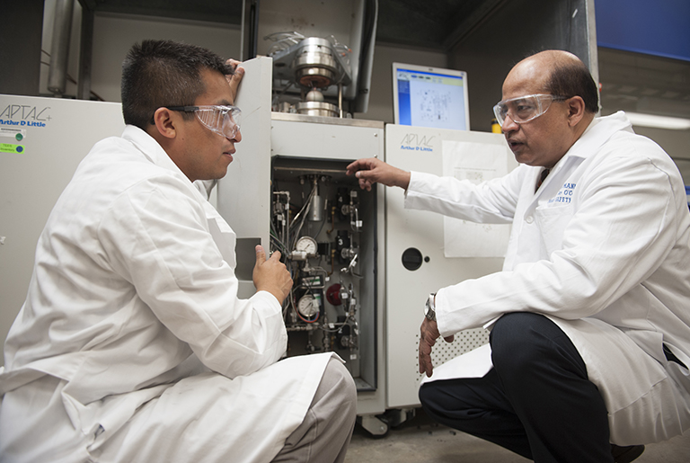 Dr. Sam Mannan and another person in lab coat, talking in a facility.