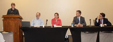 Dr. Marvin Adams on podium with panels sitting on the side.