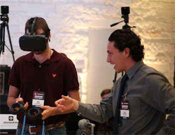 A student wearing VR googles and another student explaining.