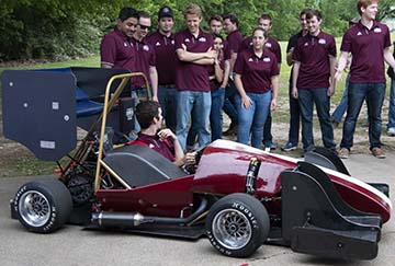 Texas A&amp;M formula racing team inspecting their race car