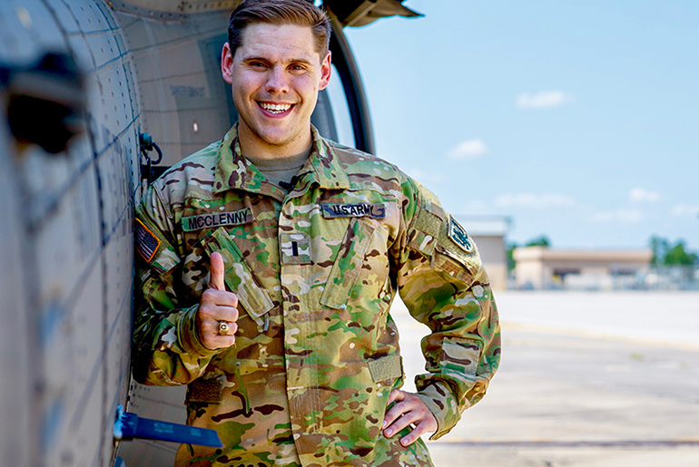 Levi McClenny standing in front of a Black Hawk helicopter.