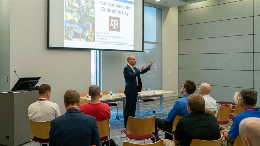 Professional giving a talk about Nuclear Security Enterprise Day to an audience