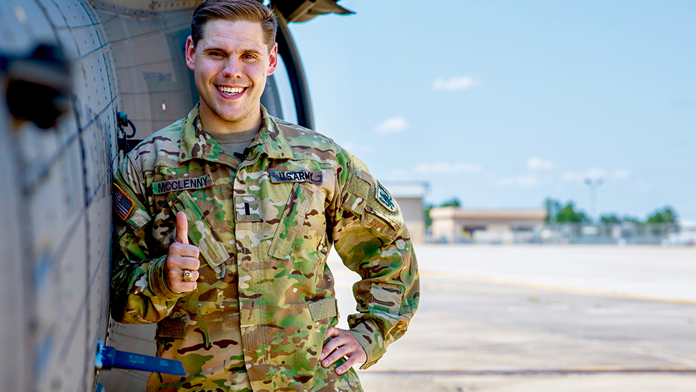 Levi McClenny US Army stands in front of a black hawk helicopter