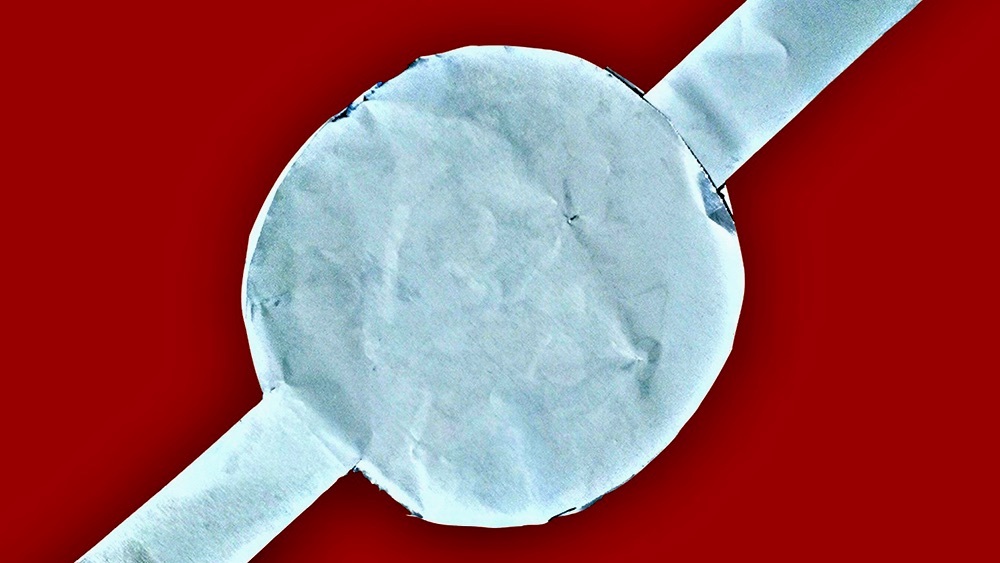A prototype of the green supercapacitor made by Dr. Hong Liang’s team shown against a red background.