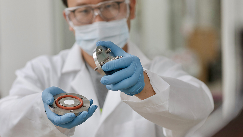 A male student holding a platform containing piece of polyimide membrane 