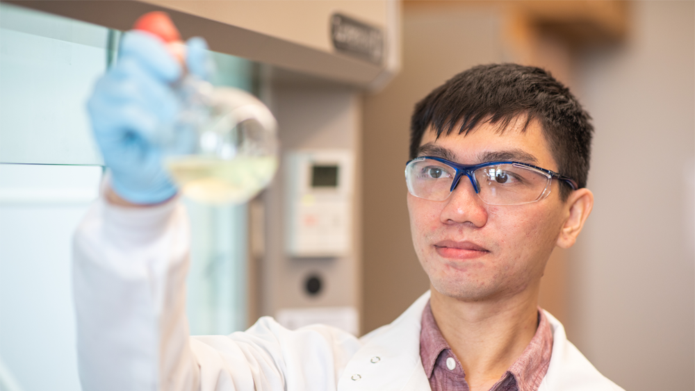 Student holding beaker filled with liquid in lab