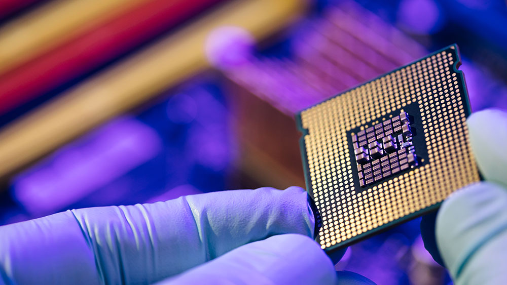 Hand with gloves holding small semiconductor chip
