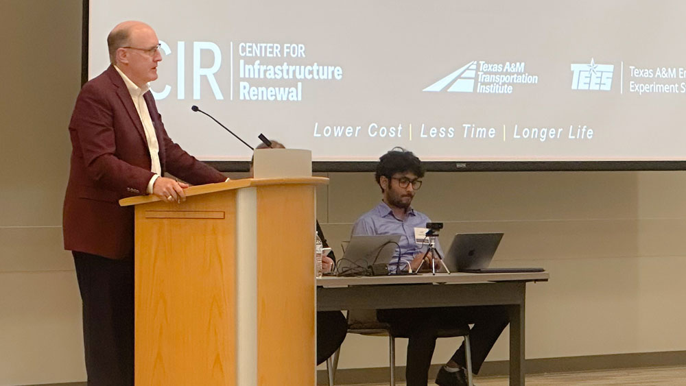 CIR Advisory Panel Board Chair John Barton stands at a podium giving a presentation.