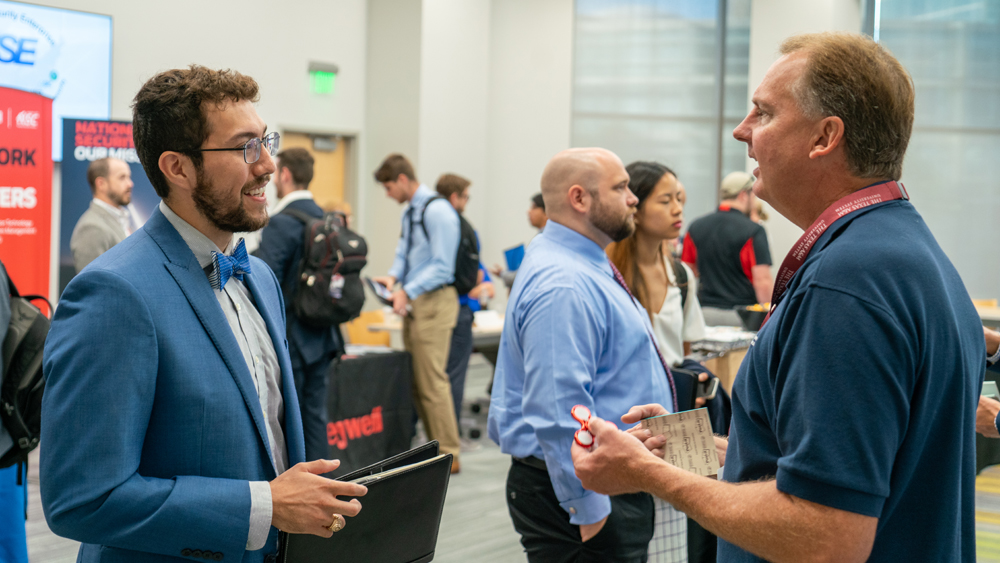 A student chats with a hiring manager at the NSE Day career fair