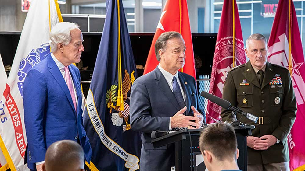 Chancellor John Sharp, U.S. Senator John Cornyn, and Gen. John “Mike” Murray in front of an audience